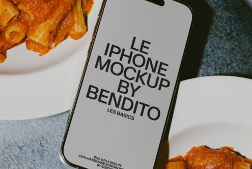 Close up iPhone with white screen mockup next to spicy pasta in white bowl