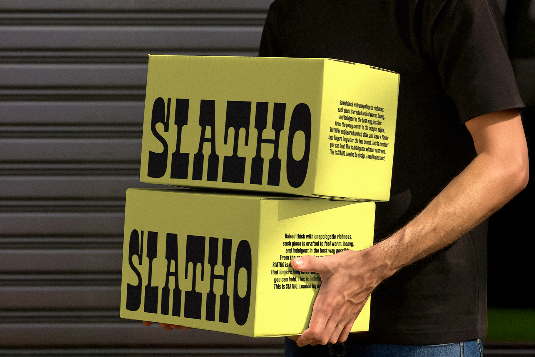 Person holding two stacked bright yellow boxes with SLATHO typeface design