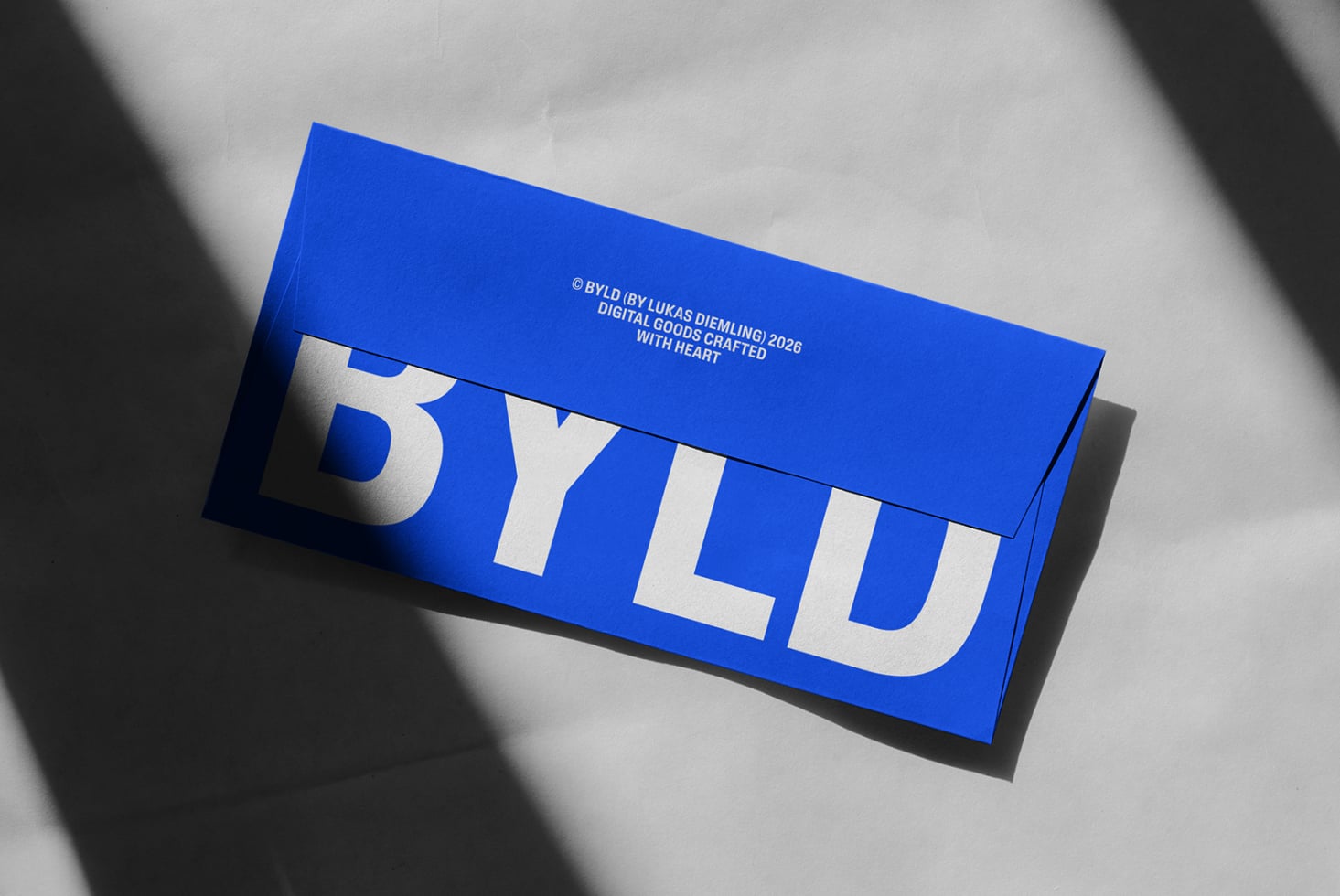 Bright blue DIN A long envelope mockup with white BYLD text on grey backdrop