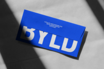 Bright blue DIN A long envelope mockup with white BYLD text on grey backdrop