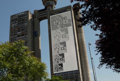 Large brutalist banner on brutalist pillar with repeated text layout