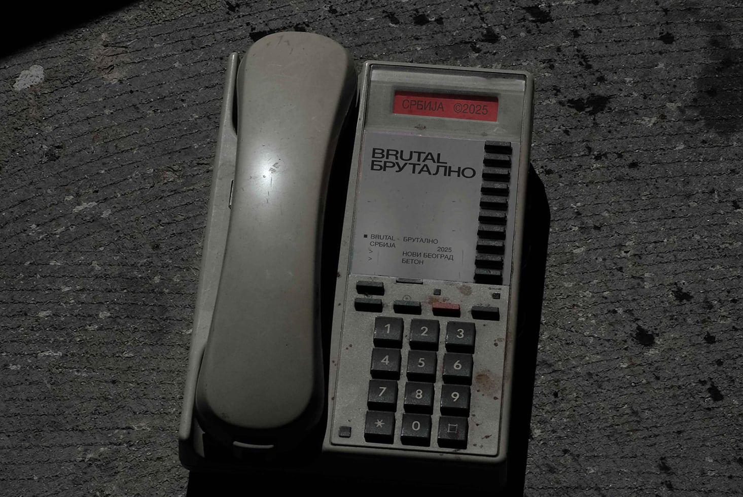 Old phone handset beside brutalist design mockup with red serbia label
