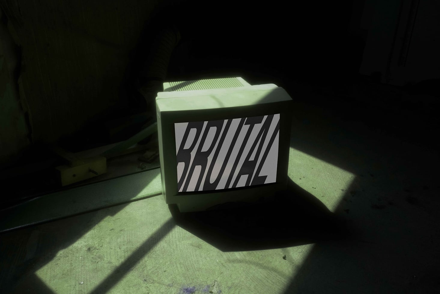 Brutal box mockup casting green shadow on concrete floor