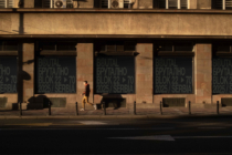 Window signage on tan stone building with person jogging brutal block mockup