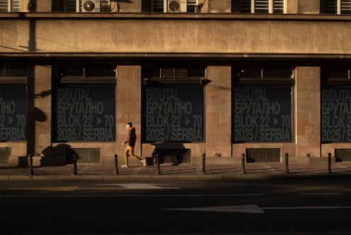Window signage on tan stone building with person jogging brutal block mockup
