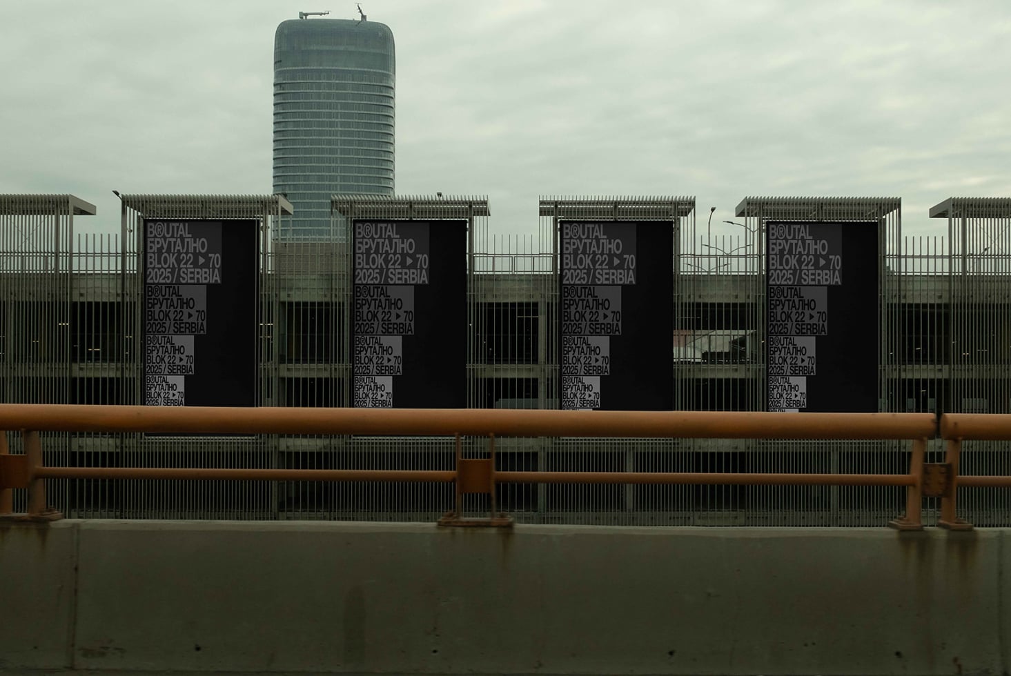 Multiple black banners on metal fence with tower behind brutal collection signage