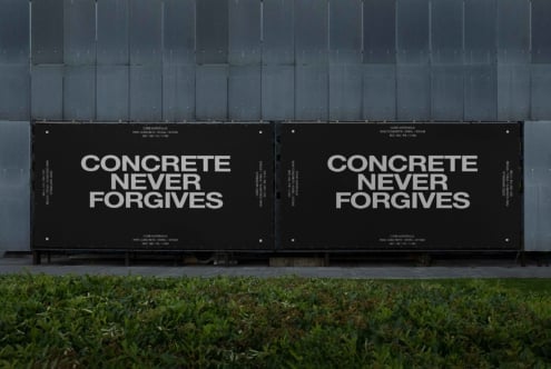 Two black outdoor billboard panels against metal wall with white typography message