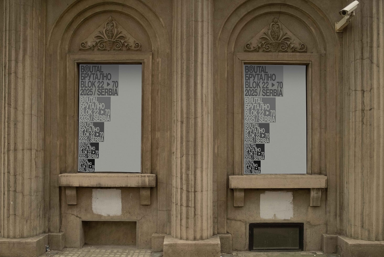 Twin arched windows in classical stone facade with frosted glass signs displaying text