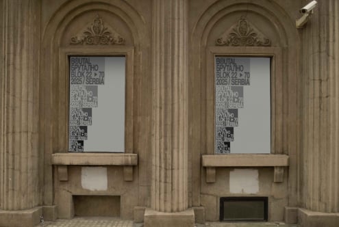 Twin arched windows in classical stone facade with frosted glass signs displaying text