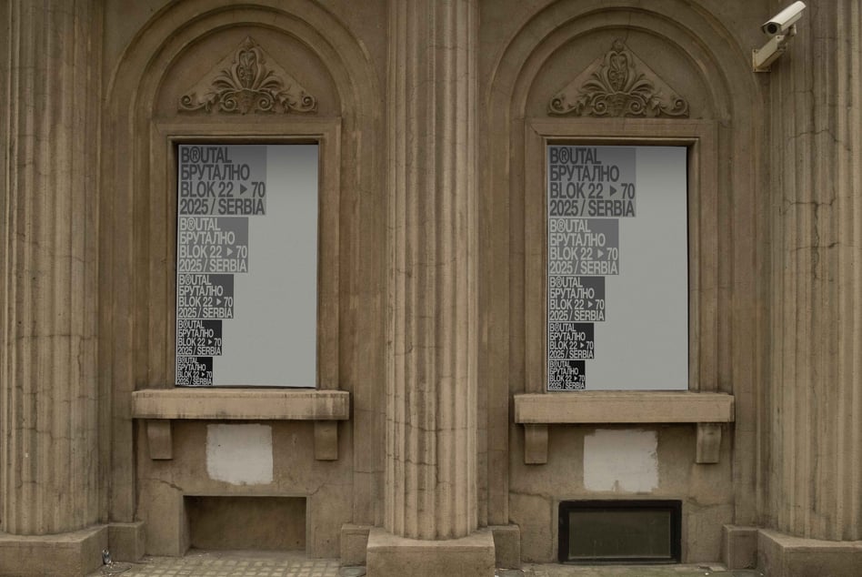 Twin arched windows in classical stone facade with frosted glass signs displaying text