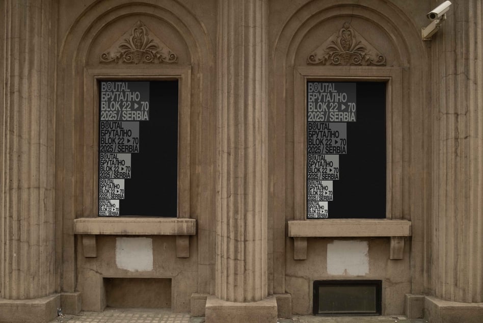 Two ornate stone arches with black window signs showing repeated text patterns