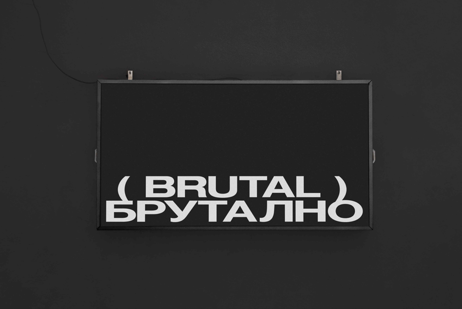 Dark horizontal sign on dark wall showing Brutal text in white sans serif letters
