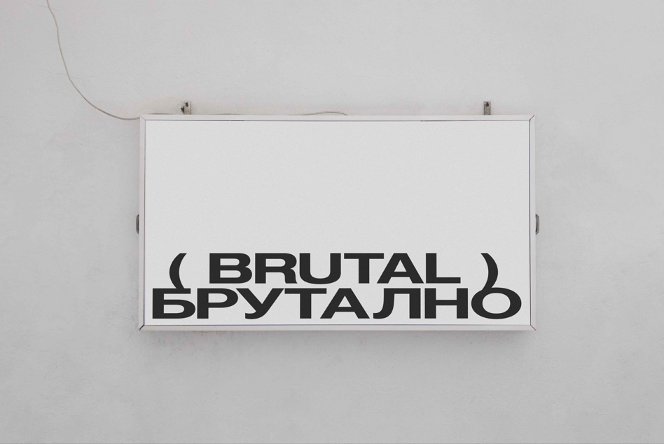 White horizontal sign mounted on wall displaying Brutal text in bold sans serif