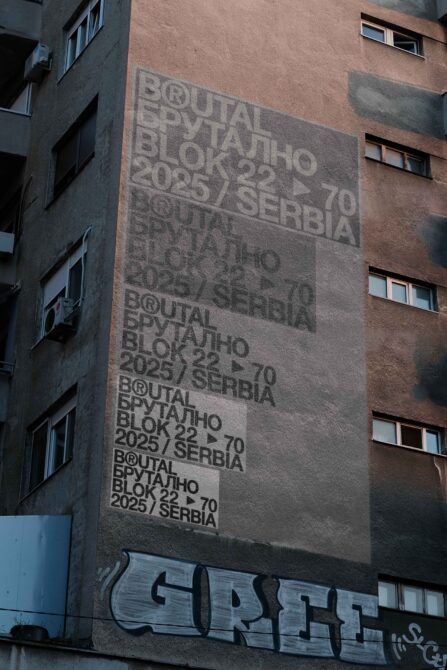 Building facade with large Brutal Brutalno stencil projection casting shadows