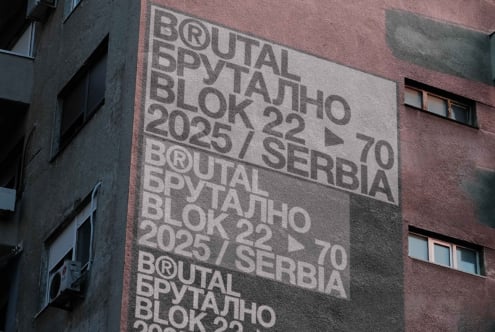 Red brick building with textured Brutal Brutalno lettering projection overhead