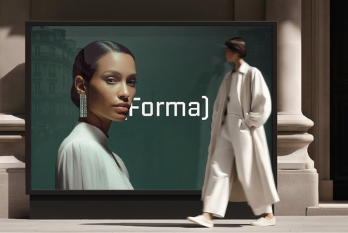 Figure in cream coat viewing oversized monitor with teal background, portrait subject visible on screen