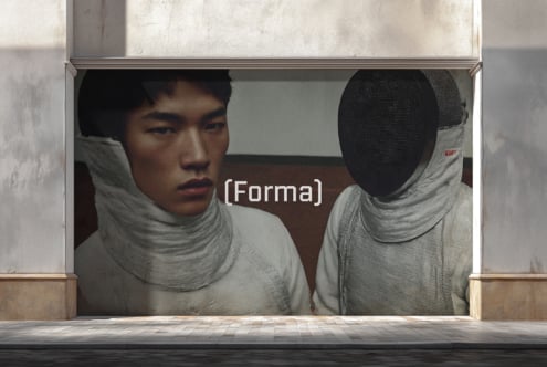Large storefront window with two figures wrapped in light fabric, one face visible, one covered