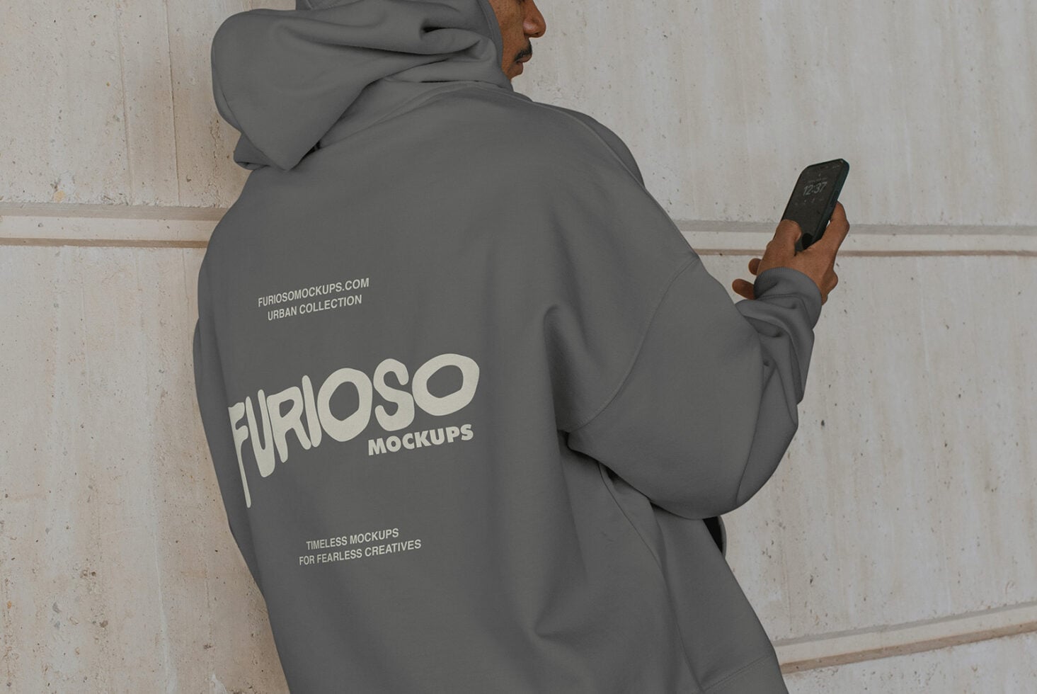 Charcoal hoodie back view with person checking phone outdoors