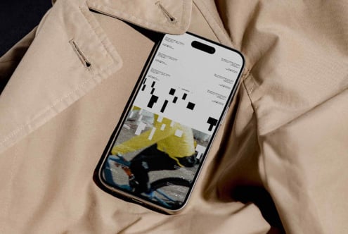 iPhone showing layout with yellow accents held in hand against dark background