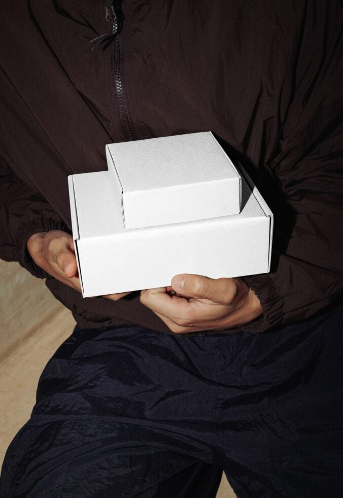 Hands holding open white cardboard shipping box mockup
