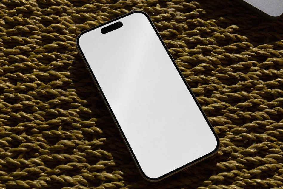 Blank phone screen mockup on woven gold texture background