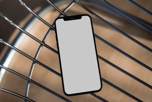 Blank white iPhone screen on striped metal background with diagonal shadow pattern