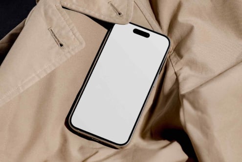 Blank white iPhone screen held against natural linen jacket material