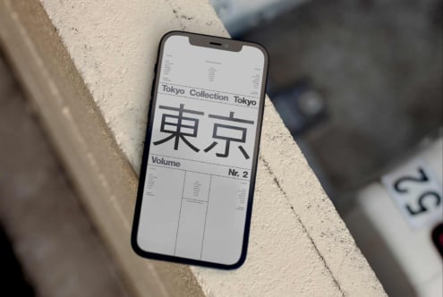 Black phone on concrete showing Tokyo Collection layout with Japanese characters