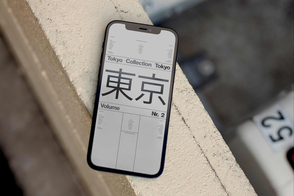 Black phone on concrete showing Tokyo Collection layout with Japanese characters