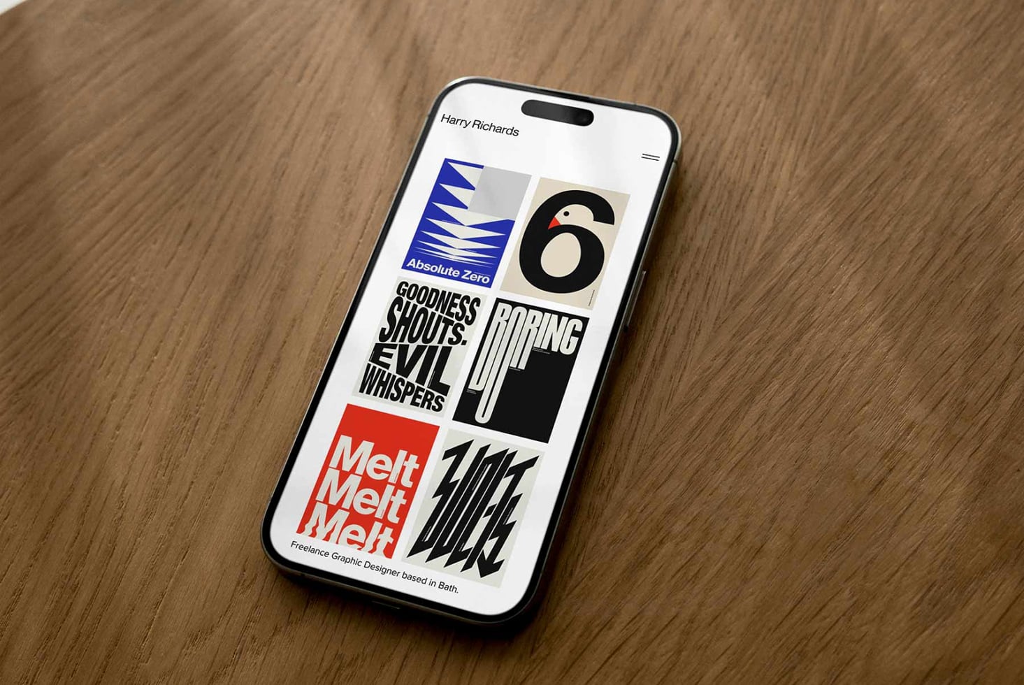 iPhone mockup displaying Harry Richards portfolio with bold typography, colorful logos, gradient text on wooden surface