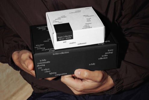 Hands holding stacked black white boxes with branded label insert