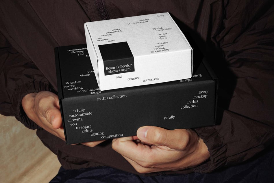 Hands holding stacked black white boxes with branded label insert