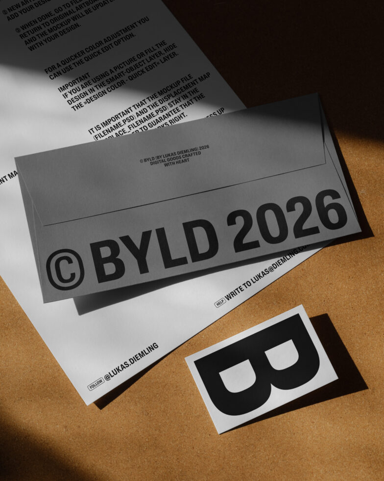 Overhead shot of gray envelope mockup, documents with BYLD branding on cork texture backdrop