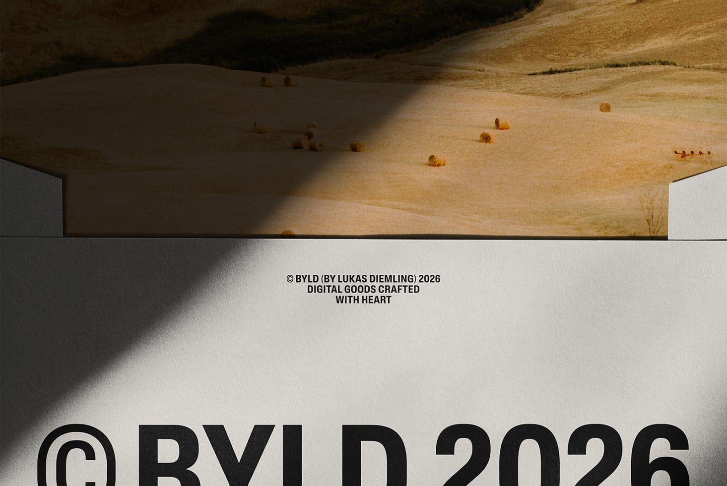 Landscape mockup with hay bales, minimalist white frame, BYLD branding on natural field scene
