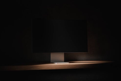 Laptop mockup on wooden shelf with dark background, blank screen