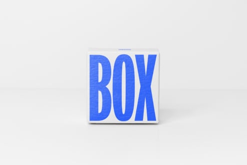 White rectangular box with chunky blue dimensional letters on minimal clean background