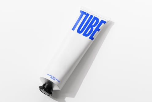 White tube with bold electric blue TUBE typography, black pump cap visible