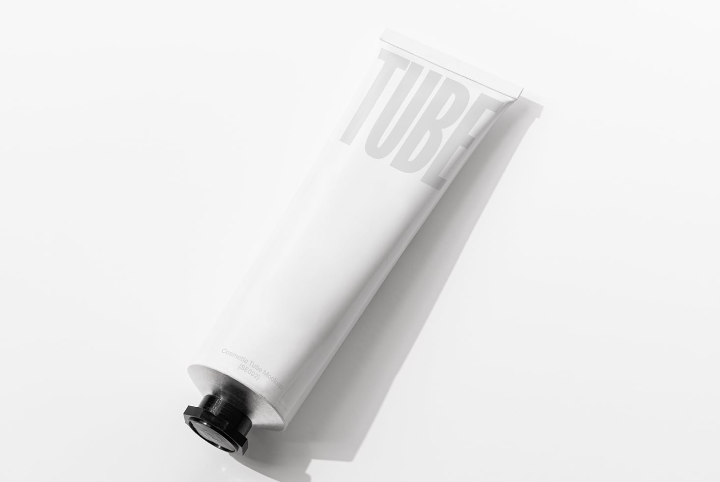 White cosmetic tube with debossed TUBE text on clean minimal background tilt