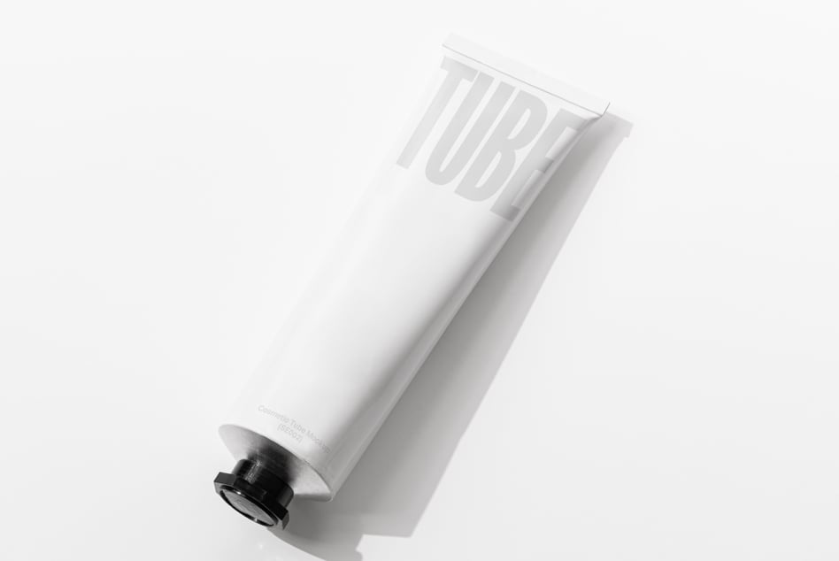 White cosmetic tube with debossed TUBE text on clean minimal background tilt