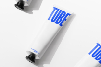 White tube with bright blue TUBE text, black cap, angled against light background