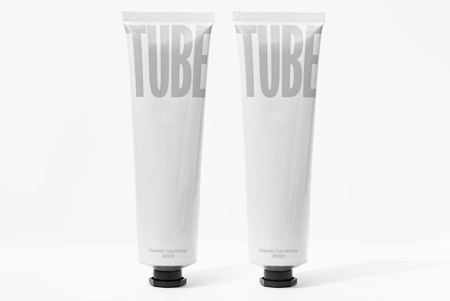Two white cosmetic tubes with embossed TUBE lettering on plain packaging