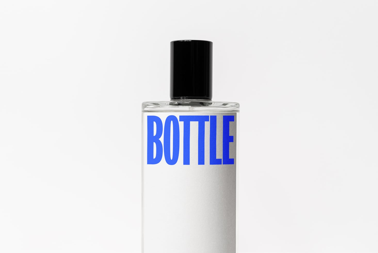 Clear cosmetic bottle with black cap, blue BOTTLE text on white label design