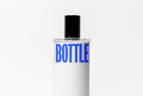 Clear cosmetic bottle with black cap, blue BOTTLE text on white label design