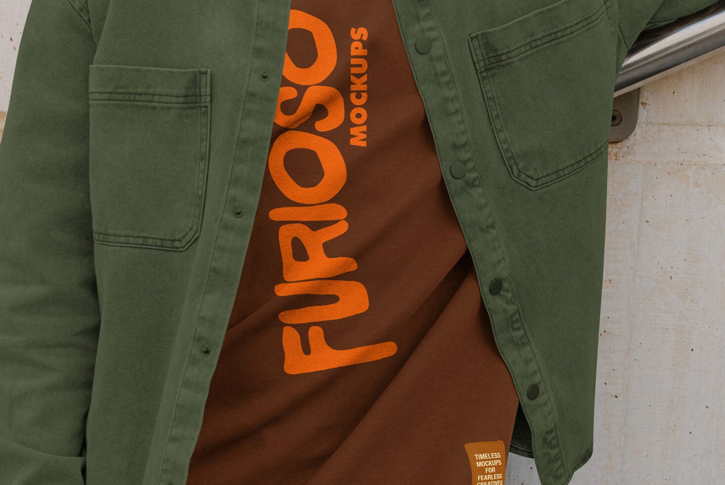 Overhead shot of open green jacket showing brown Furioso tee with orange lettering