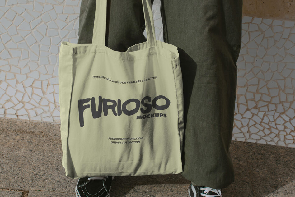 Pale yellow tote with dark Furioso Mockups lettering sitting against wall backdrop