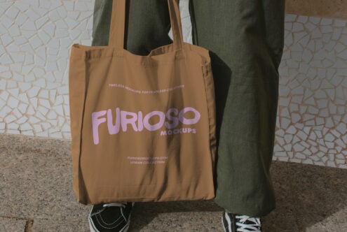 Tan tote featuring lavender Furioso Mockups logo text held by hand