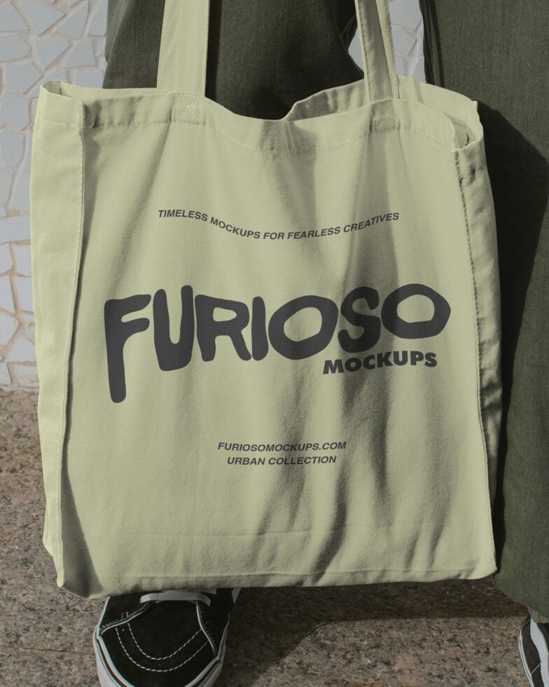 Pale yellow tote held by person wearing vintage sneakers, bold black Furioso Mockups text