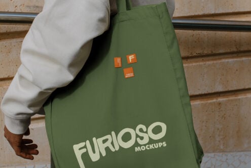 Olive green tote bag with cream Furioso Mockups branding, three orange label patches visible