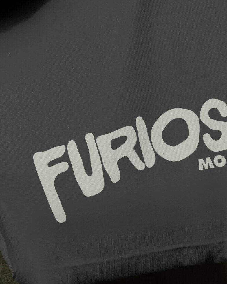 Close-up of cream Furioso text printed on black tee fabric with slight tilt