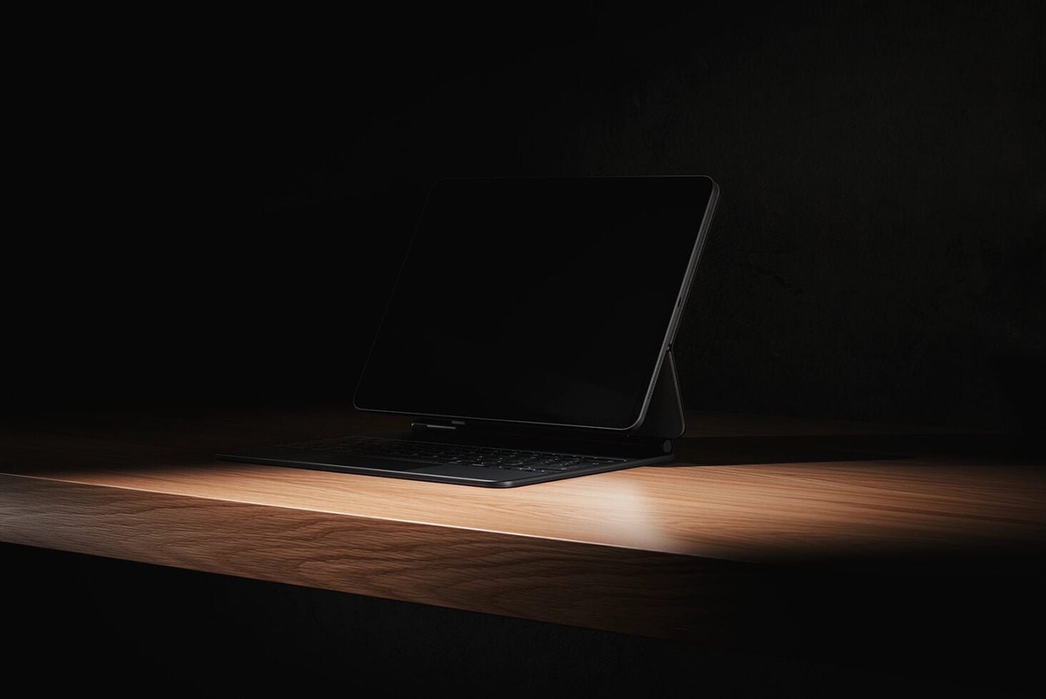Tablet mockup standing on wooden surface with black screen in dark room